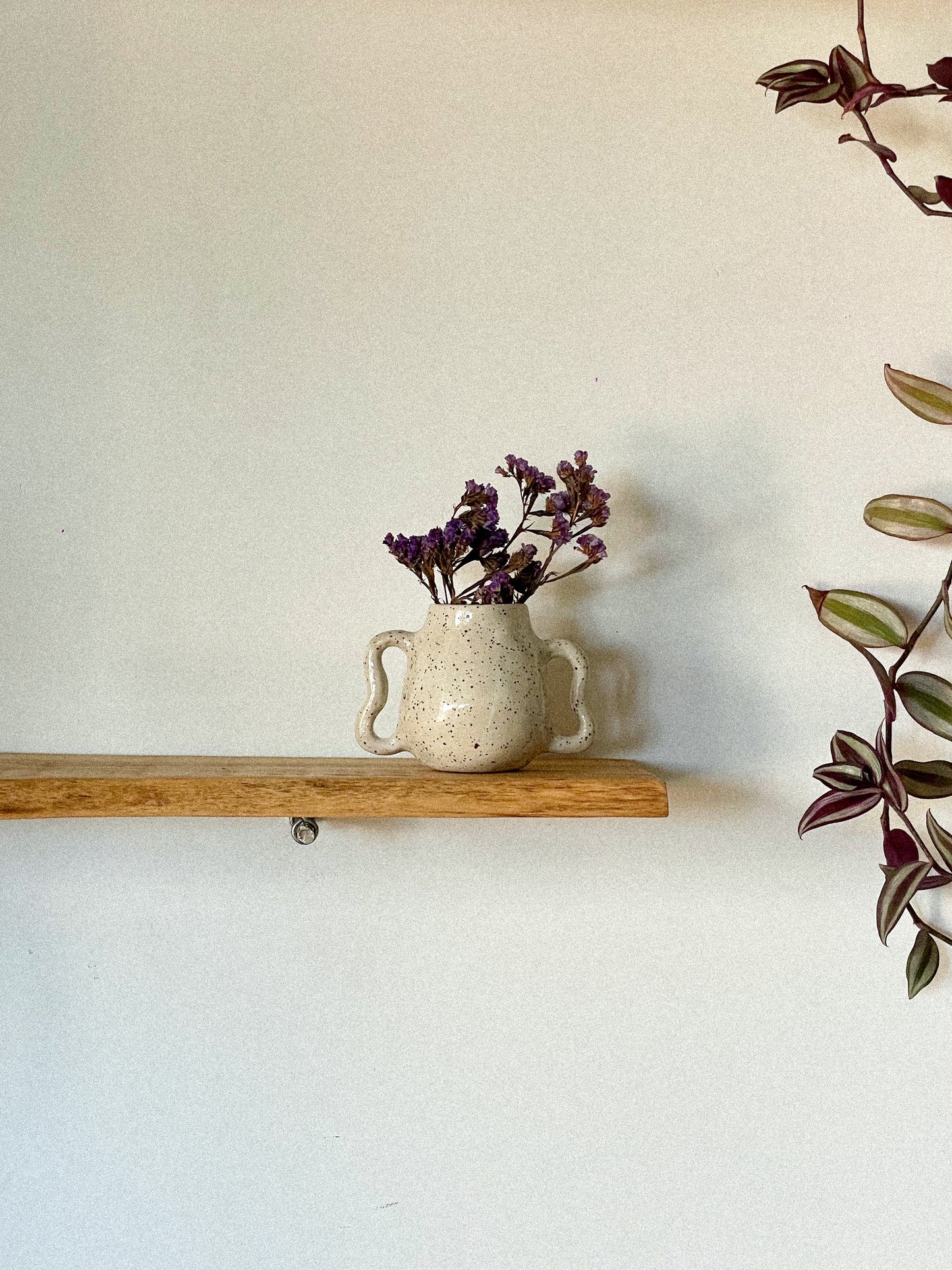 Handmade ceramic vase with wavy handles and speckled effect