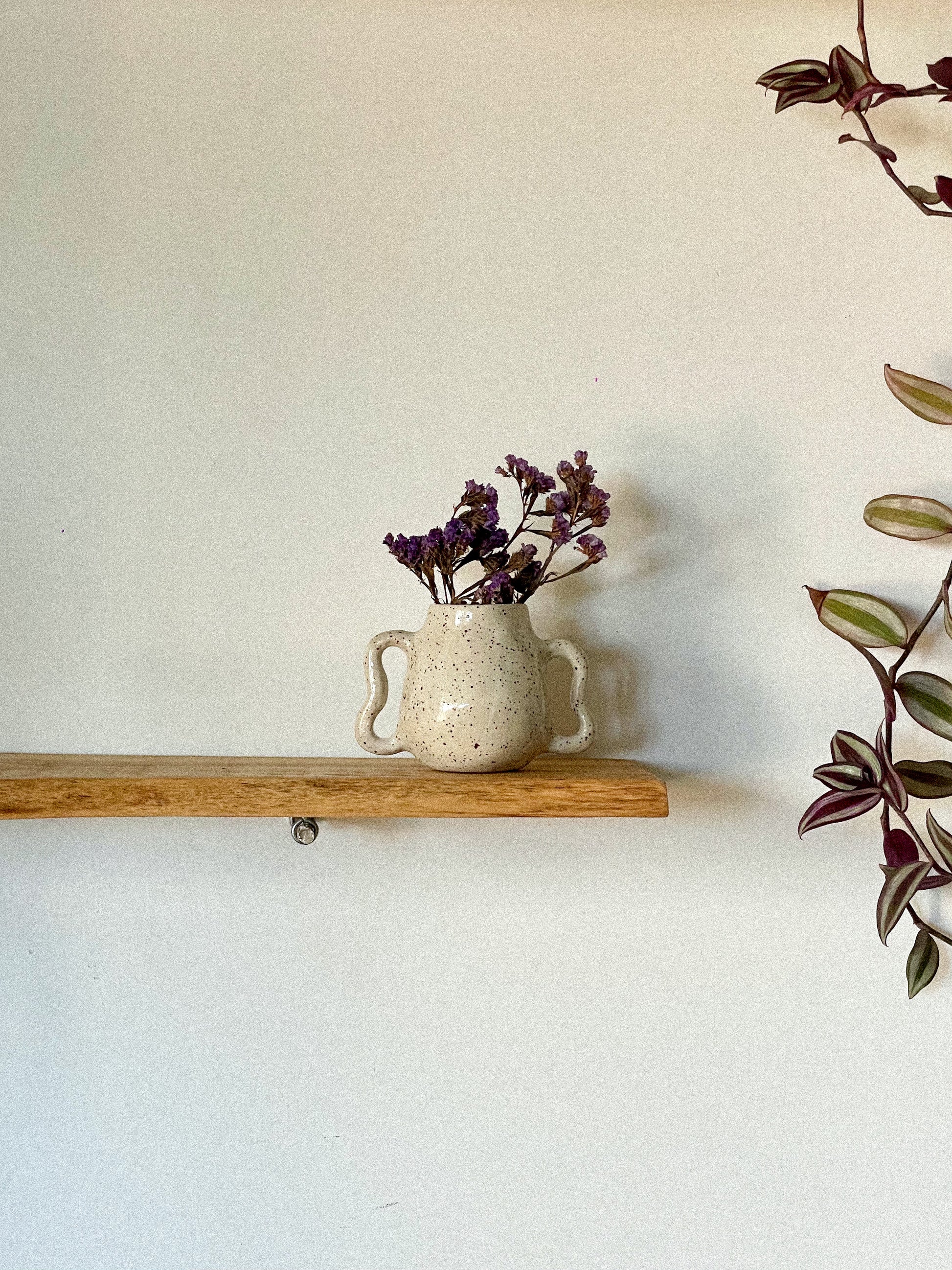 Handmade ceramic vase with wavy handles and speckled effect