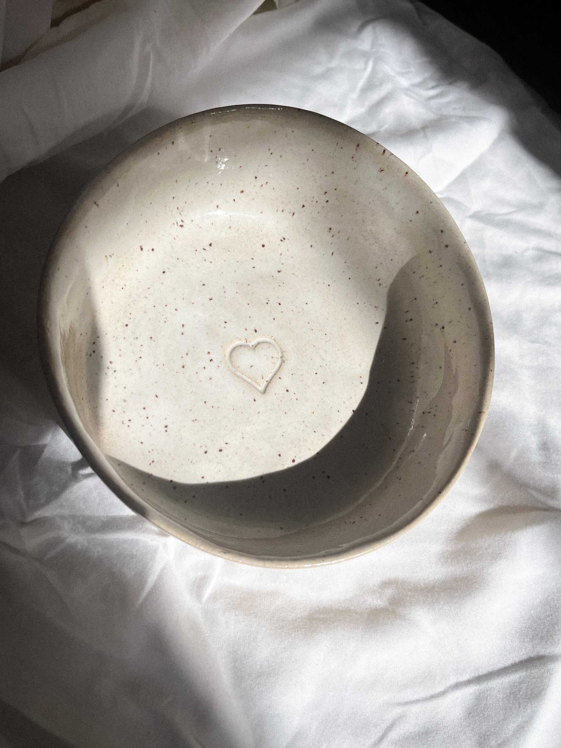Ceramic bowl with a heart. White and with spackled effect.
